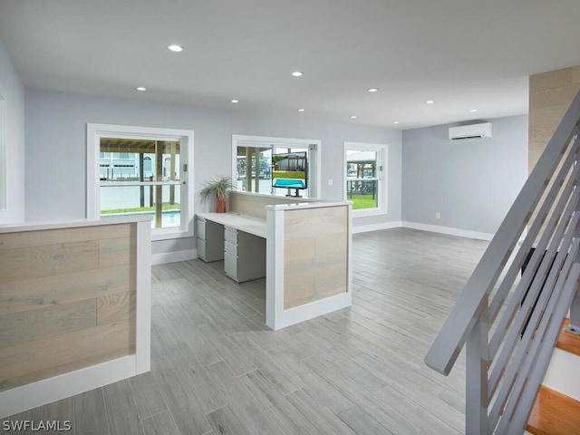 kitchen with light wood-type flooring and a wall unit AC