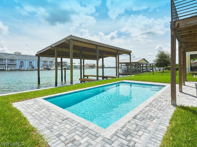 view of swimming pool featuring a yard and a water view