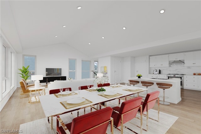 dining room with light wood-type flooring and vaulted ceiling