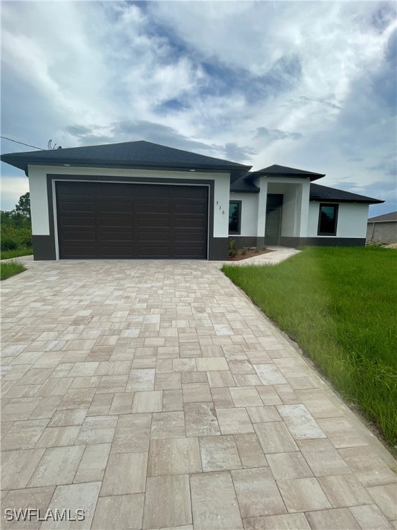 view of front of property with a garage and a front lawn