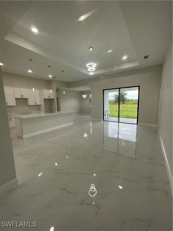 unfurnished room with a tray ceiling and sink