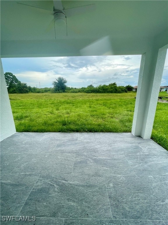 view of patio featuring ceiling fan and a rural view