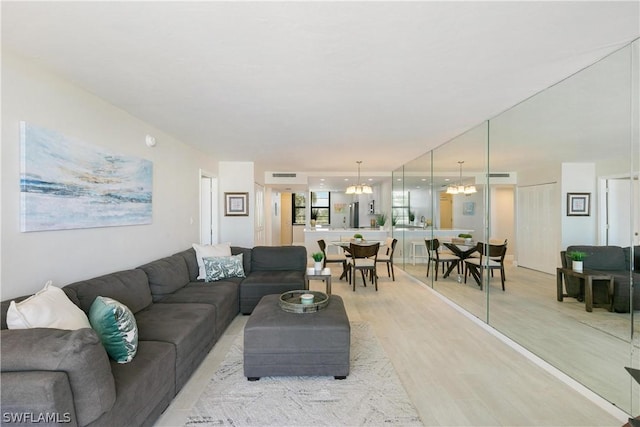 living room with a notable chandelier and light hardwood / wood-style floors