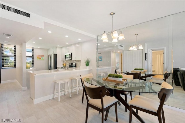 dining space with sink and an inviting chandelier