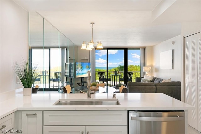 kitchen featuring an inviting chandelier, white cabinetry, stainless steel dishwasher, and sink