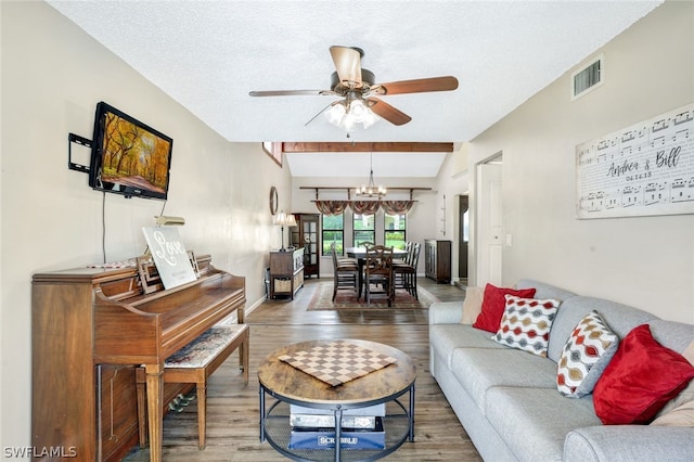 living area featuring ceiling fan with notable chandelier, visible vents, a textured ceiling, and wood finished floors