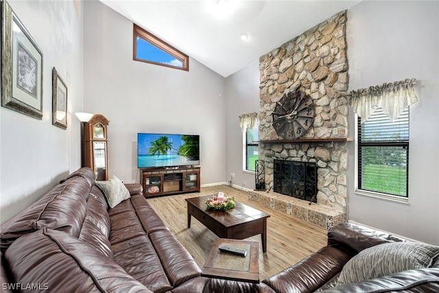 living room with high vaulted ceiling, plenty of natural light, a fireplace, and wood finished floors