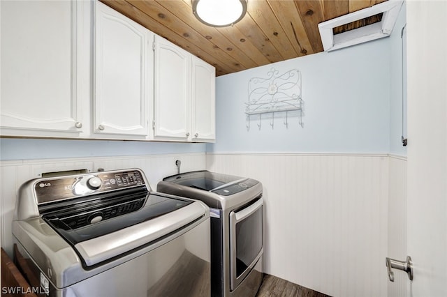 laundry room with a wainscoted wall, washer and clothes dryer, wooden ceiling, and cabinet space