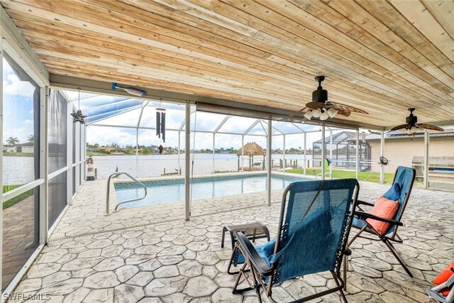 pool featuring a lanai, a water view, a ceiling fan, and a patio