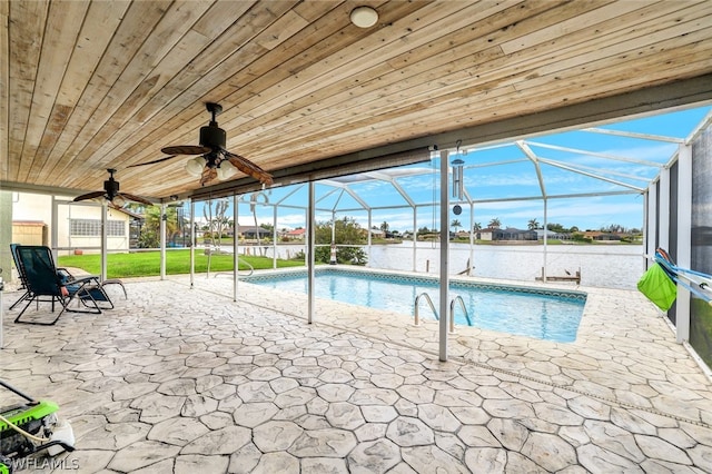 pool featuring glass enclosure, a patio, a water view, and ceiling fan