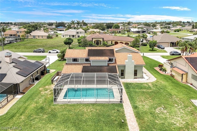 pool featuring a lanai, a residential view, and a yard