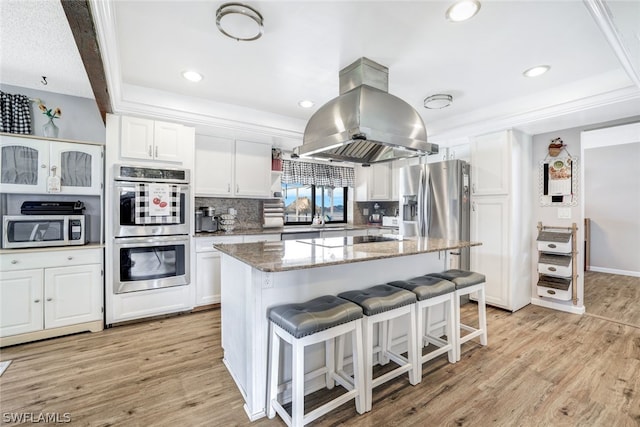 kitchen featuring stainless steel appliances, light wood-type flooring, white cabinetry, and island exhaust hood