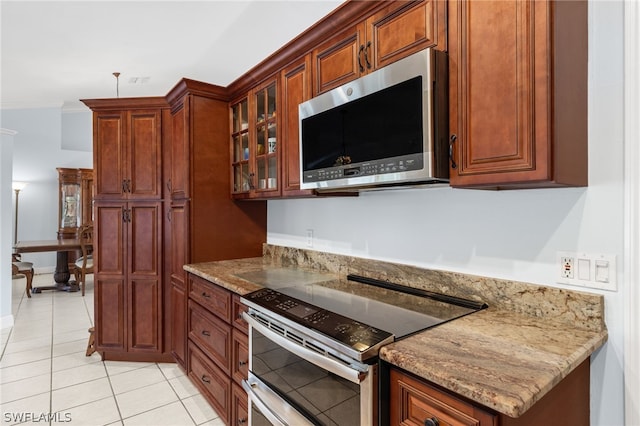 kitchen with light stone counters, stainless steel appliances, and light tile patterned floors