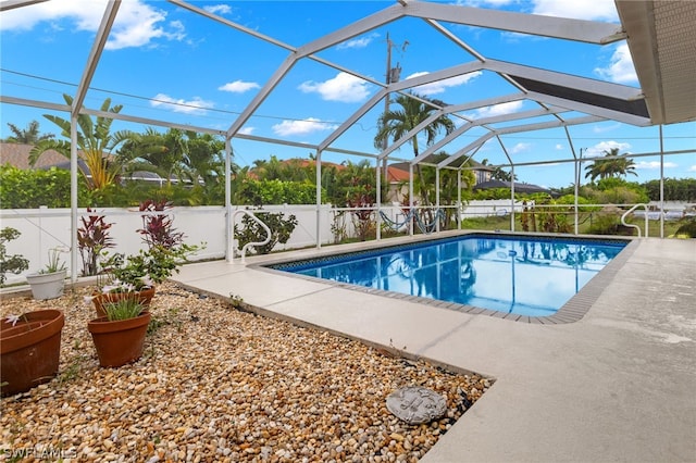 view of swimming pool with a patio area and glass enclosure