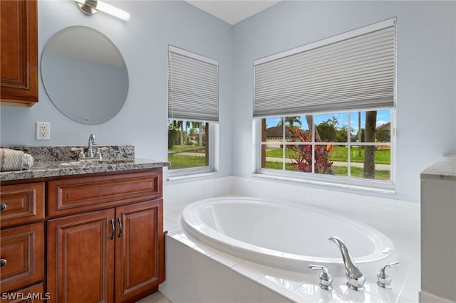 bathroom with vanity and tiled bath