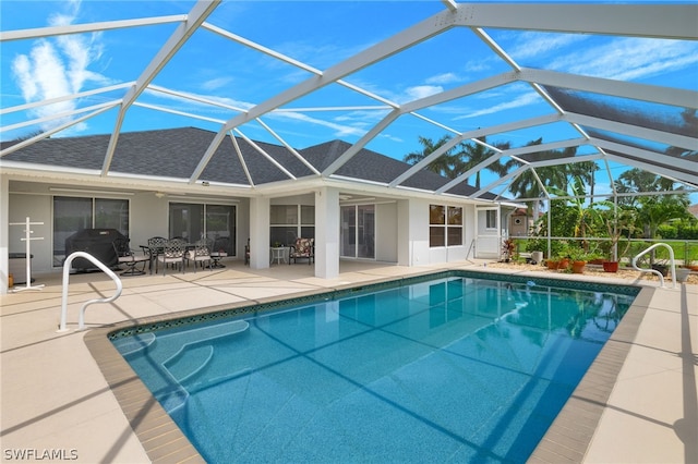 view of pool featuring area for grilling, a patio area, and glass enclosure