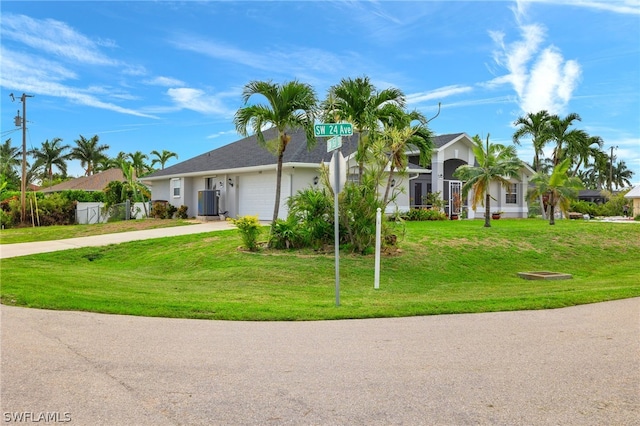 single story home with cooling unit, a garage, and a front yard