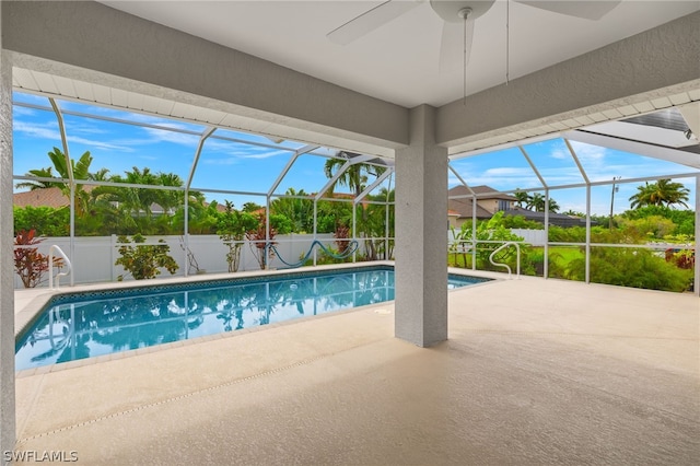 view of pool featuring a patio area, ceiling fan, and glass enclosure