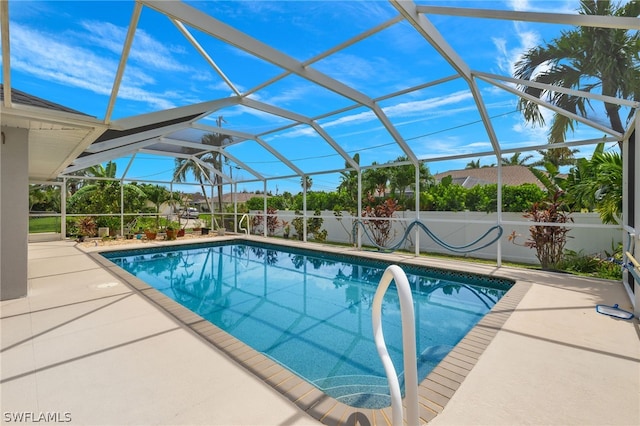 view of swimming pool featuring a lanai and a patio