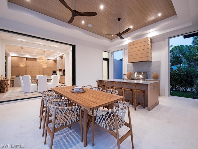 dining space with a tray ceiling, ceiling fan, and wood ceiling