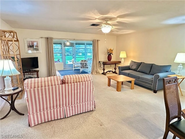 carpeted living room with ceiling fan