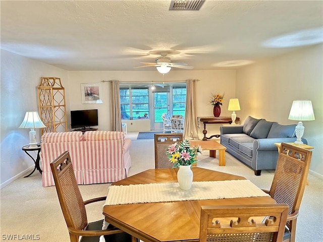 carpeted dining space with ceiling fan