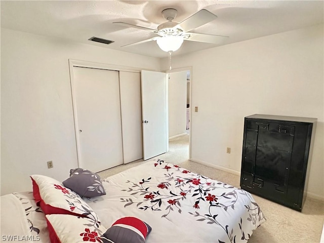 bedroom featuring light carpet, a closet, and ceiling fan