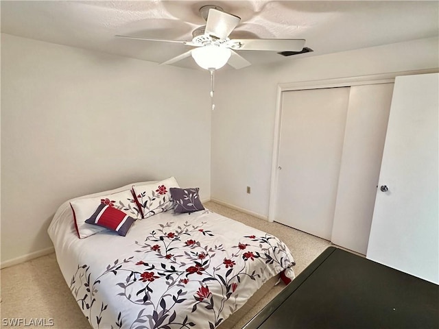 bedroom with light colored carpet, a closet, and ceiling fan