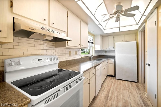 kitchen featuring a skylight, sink, ceiling fan, white appliances, and light hardwood / wood-style flooring