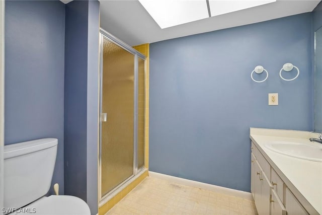 bathroom with a skylight, vanity, toilet, and an enclosed shower