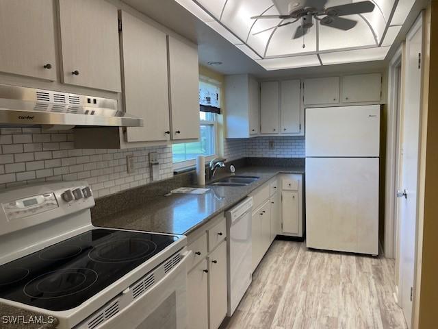 kitchen featuring sink, light wood-type flooring, decorative backsplash, ceiling fan, and white appliances