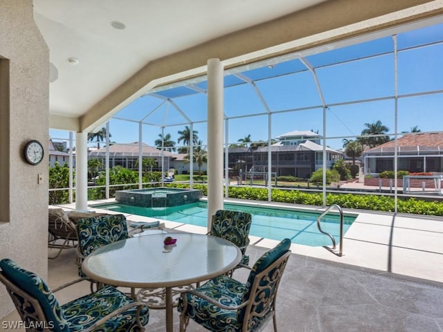 view of swimming pool with glass enclosure, an in ground hot tub, and a patio area