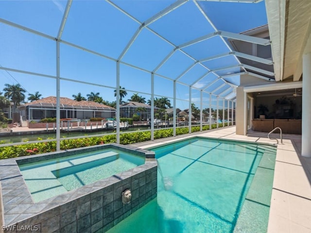 view of pool featuring a lanai and an in ground hot tub