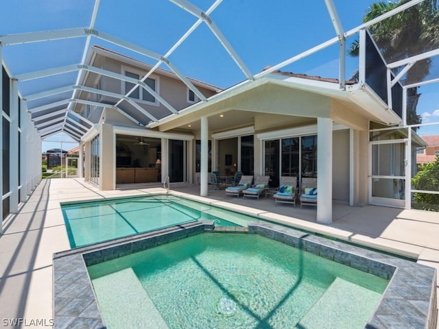 view of pool with glass enclosure and a patio area