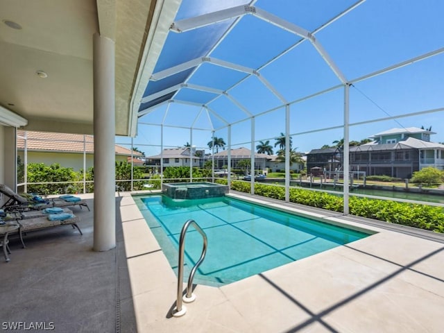 view of swimming pool featuring an in ground hot tub, a patio area, and a lanai