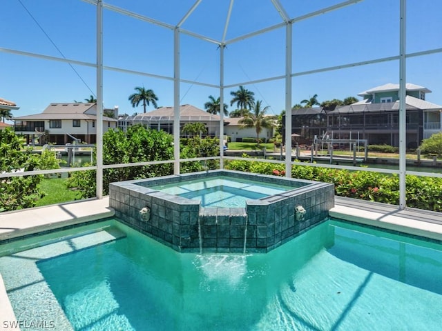 view of pool with a lanai and an in ground hot tub