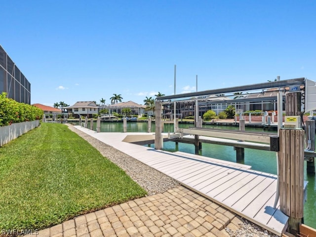 view of dock with a yard and a water view