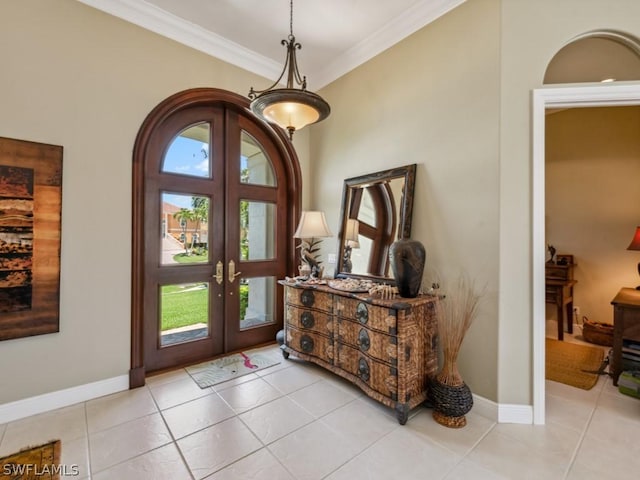 foyer entrance with crown molding, french doors, and light tile patterned floors