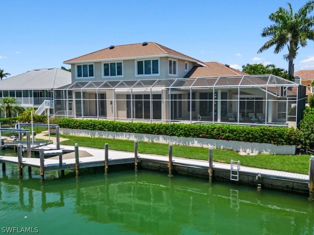 rear view of house featuring glass enclosure and a water view