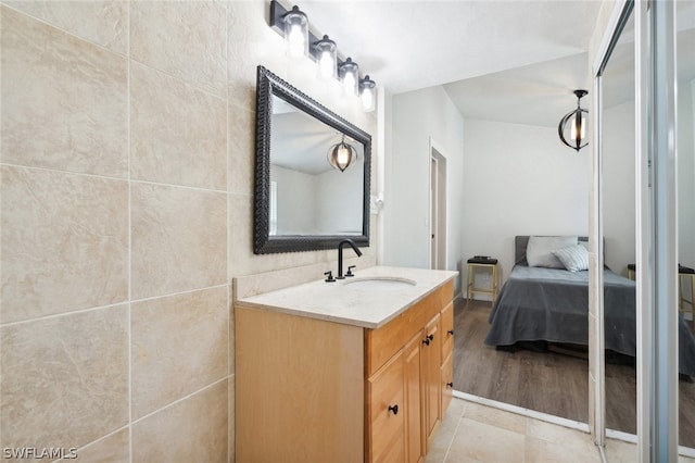 bathroom featuring tile walls, hardwood / wood-style floors, and vanity