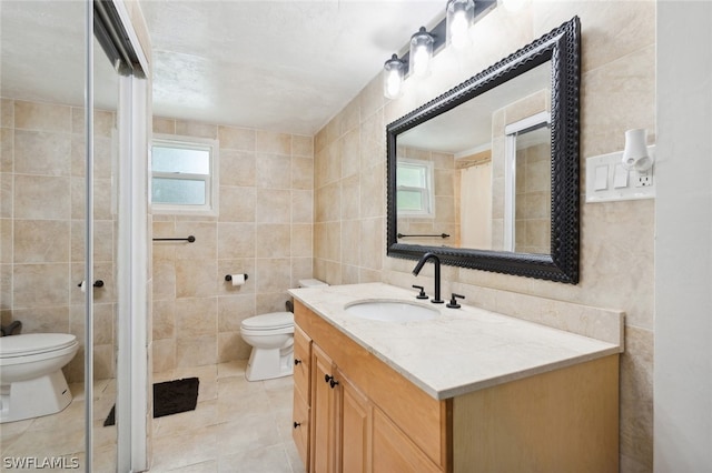 bathroom featuring vanity, tile walls, toilet, and tile patterned flooring