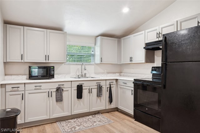 kitchen with light hardwood / wood-style flooring, white cabinets, black appliances, vaulted ceiling, and sink