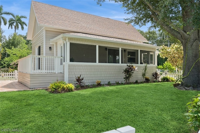 bungalow-style house featuring a sunroom and a front yard