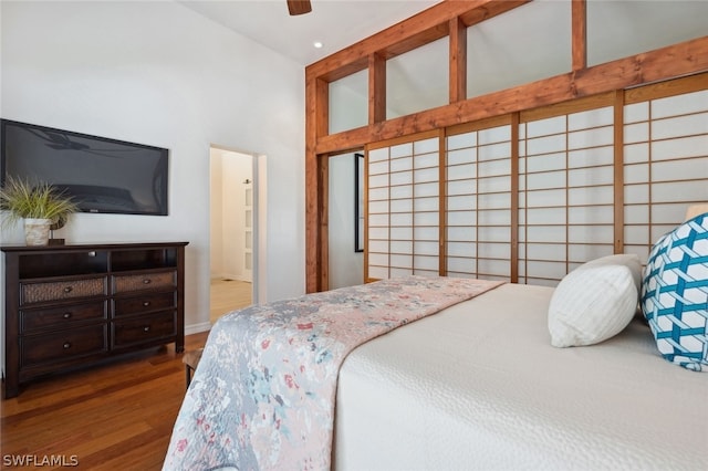 bedroom featuring ensuite bathroom, ceiling fan, high vaulted ceiling, and dark wood-type flooring