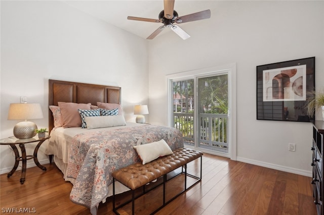 bedroom featuring ceiling fan, access to outside, light hardwood / wood-style flooring, and a towering ceiling