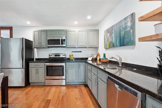 kitchen featuring sink, appliances with stainless steel finishes, light wood-type flooring, and gray cabinets