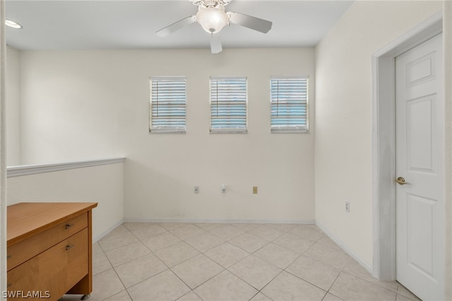 tiled spare room with ceiling fan