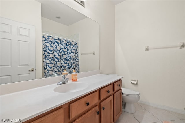 bathroom with toilet, vanity, and tile patterned floors