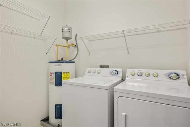 laundry room with electric water heater and washing machine and clothes dryer