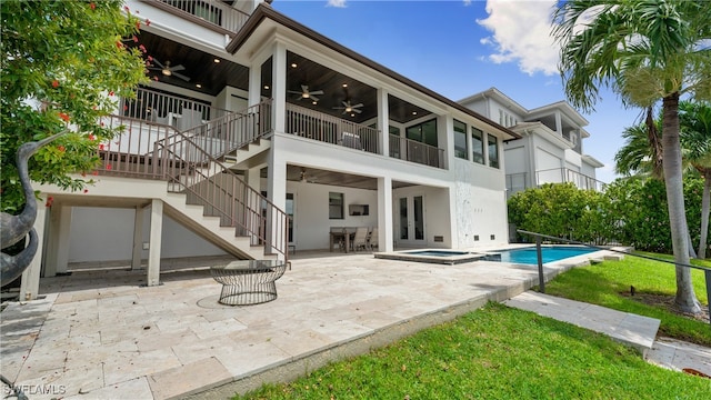 rear view of house with a swimming pool with hot tub, ceiling fan, and a patio area